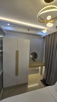 a bedroom with a white cabinet and a mirror at Sheena's Suite by Staycation in Manila