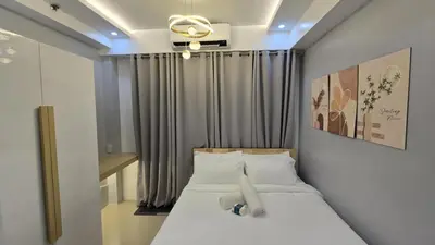 a bedroom with a bed with a ceiling fan at Sheena's Suite by Staycation in Manila