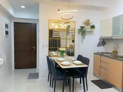 a kitchen with a table and chairs in a kitchen at Hometel by ECR at Viceroy Residences in Manila