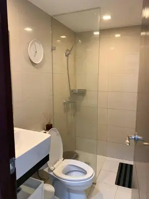 a bathroom with a shower and a toilet and a sink at Hometel by ECR at Viceroy Residences in Manila