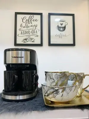 a coffee maker and a cup on a counter at Hometel by ECR at Viceroy Residences in Manila