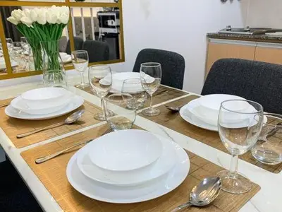a table with white plates and wine glasses on it at Hometel by ECR at Viceroy Residences in Manila