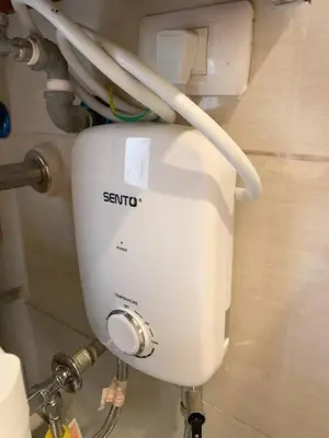a white toilet in a bathroom with some pipes at Hometel by ECR at Viceroy Residences in Manila