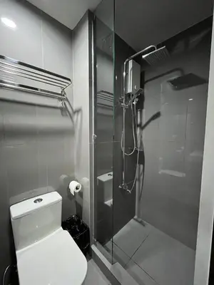 a bathroom with a toilet and a glass shower at Escape Haven in Manila