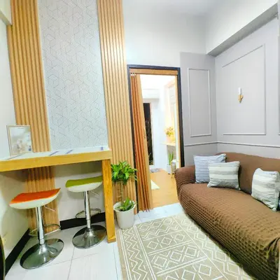a living room with a couch and a mirror at 1BR Cozy Home with Balcony Near NAIA Terminals in Manila