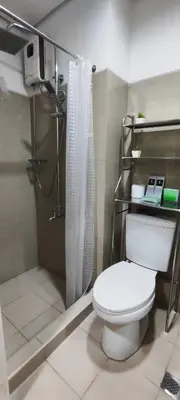 a bathroom with a toilet and a shower at All I Want Relax at Shore Residences in MOA Complex in Manila