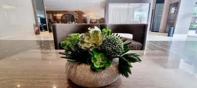 a vase with flowers on a table in a lobby at All I Want Relax at Shore Residences in MOA Complex in Manila
