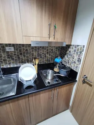 a small kitchen with a sink and a stove at Mall of Asia Staycation shore 3 in Manila