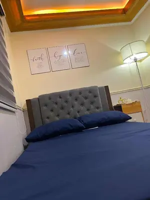 a bedroom with a blue bed with certificates on the wall at Balai Sais - Your Scenic Home Away from Home! in Binangonan