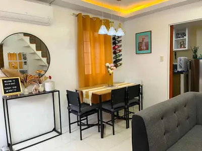 a dining room with a table and chairs and a mirror at Balai Sais - Your Scenic Home Away from Home! in Binangonan