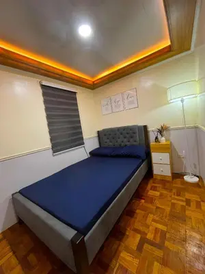 a bedroom with a blue bed in a room at Balai Sais - Your Scenic Home Away from Home! in Binangonan