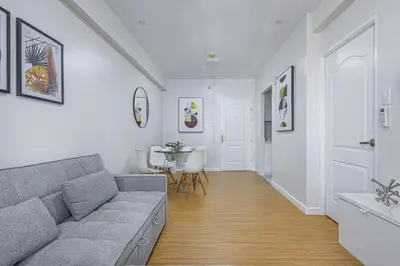 a living room with a couch and a table at 1 BR Central and Cozy Condo Prime Location in BGC in Manila