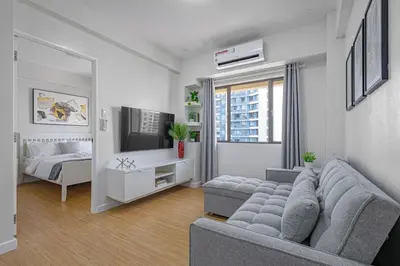 a living room with a couch and a bed at 1 BR Central and Cozy Condo Prime Location in BGC in Manila