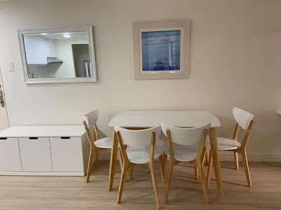 a table and chairs in a room with a mirror at Comfy and Renovated 1 BR with Balcony BGC Golf View in Manila