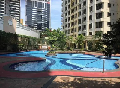 a large pool in a city with tall buildings at Comfy and Renovated 1 BR with Balcony BGC Golf View in Manila