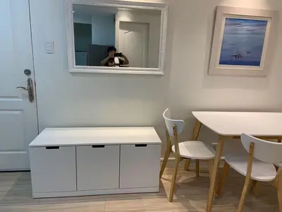 a person taking a picture of a table and a mirror at Comfy and Renovated 1 BR with Balcony BGC Golf View in Manila