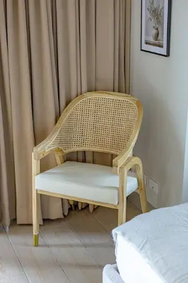 a wicker chair in a room with a bed at Stylish 2 BR Home with Bathtub and Balcony Uptown BGC in Manila