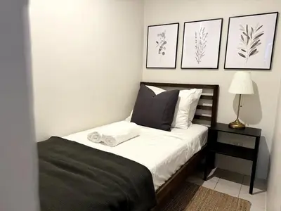 a bedroom with a bed with black and white at Modern Luxe 3 BR Home BGC in Manila