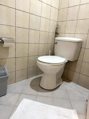 a bathroom with a toilet in a tiled room at Modern Luxe 3 BR Home BGC in Manila