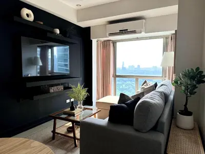 a living room with a couch and a large window at Modern Luxe 3 BR Home BGC in Manila