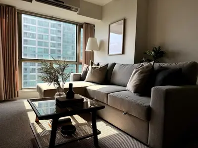 a living room with a couch and a table at Modern Luxe 3 BR Home BGC in Manila