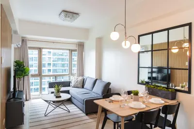a living room with a couch and a table at Scandi 1 BR Home Golf View BGC in Manila