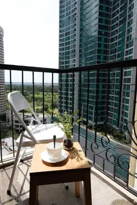 a room with a table and a chair on a balcony at Golf Penthouse Balcony BGC in Manila