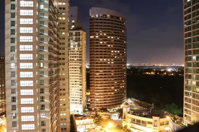 a view of a city at night with tall buildings at Julias Bright Stylish Condo Balcony in Manila