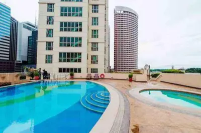 a large swimming pool in front of a building at Julias Tropical Oasis Golf Skyline View in Manila