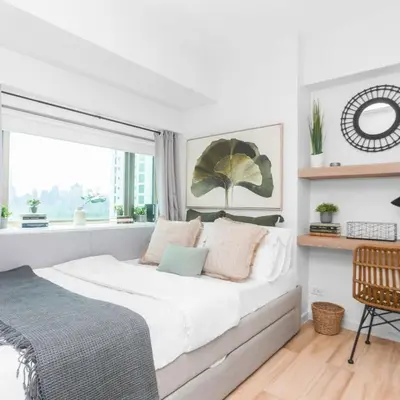 a white bedroom with a large bed and a window at Julias Tropical Oasis Golf Skyline View in Manila