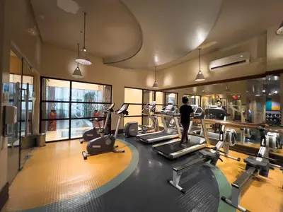 a gym with treadmills and elliptical machines at Julias Tropical Oasis Golf Skyline View in Manila