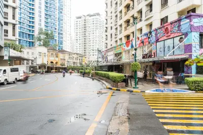 an empty street in a city with tall buildings at Julias Tropical Oasis Golf Skyline View in Manila
