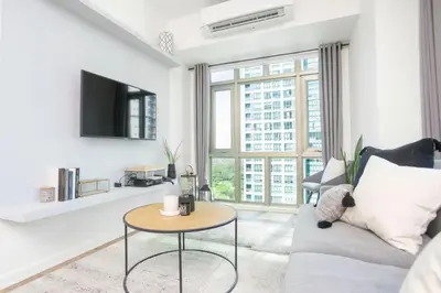 a living room with a couch and a table at Julias Upscale Airy Getaway 1 BR Golf View in Manila