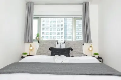 a bedroom with a white bed with a large window at Julias Upscale Airy Getaway 1 BR Golf View in Manila
