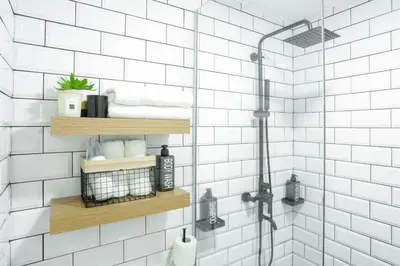 a bathroom with white tiled walls and a shower at Julias Upscale Airy Getaway 1 BR Golf View in Manila
