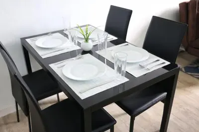 a black dining table with plates and glasses on it at Julias Attractive and Cozy Penthouse Golf View in Manila