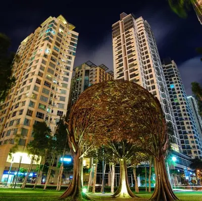 a sculpture of a tree in front of tall buildings at Julias Attractive and Cozy Penthouse Golf View in Manila