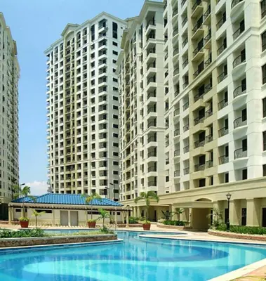a swimming pool in front of two large buildings at Julias Attractive and Cozy Penthouse Golf View in Manila