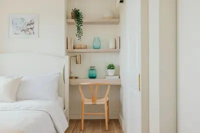 a bedroom with a table and a chair next to a bed at Modern Coastal Design 1 BR Condo Golf View BGC in Manila