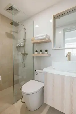 a bathroom with a toilet and a sink and a shower at Modern Coastal Design 1 BR Condo Golf View BGC in Manila