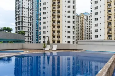 an empty swimming pool with tall buildings in the background at Modern Coastal Design 1 BR Condo Golf View BGC in Manila