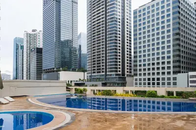 a pool in the middle of a city with tall buildings at Modern Coastal Design 1 BR Condo Golf View BGC in Manila