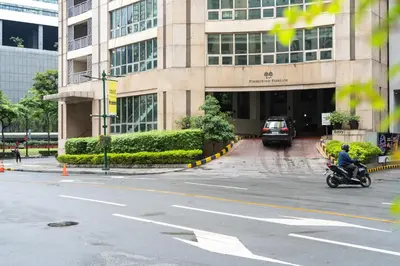 a man riding a motorcycle in front of a building at Modern Coastal Design 1 BR Condo Golf View BGC in Manila