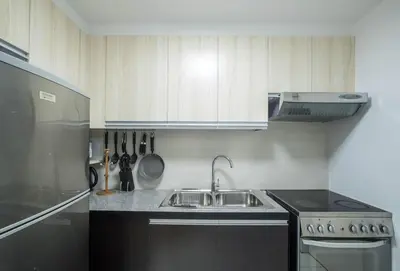 a kitchen with a sink and a stove at Julias Contemporary Apt Balcony and Golf View in Manila