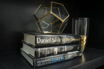 a stack of books sitting on a table with a glass at Julias Contemporary Apt Balcony and Golf View in Manila