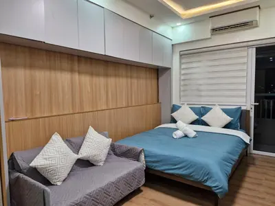 a bedroom with two beds and a couch at Comfy Stay 50 mbps Wi-Fi, Smart TV, Netflix in Manila