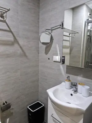 a bathroom with a white sink and a mirror at Comfy Stay 50 mbps Wi-Fi, Smart TV, Netflix in Manila