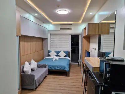 a bedroom with a bed and a couch in a room at Comfy Stay 50 mbps Wi-Fi, Smart TV, Netflix in Manila