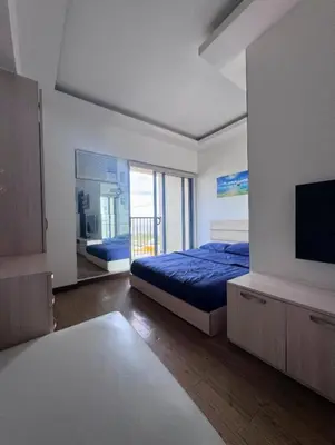a bedroom with a bed and a tv in it at Chelsea Tower by Calvin in Manila