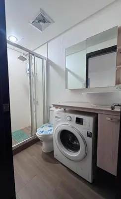 a bathroom with a washing machine and a toilet at Chelsea Tower by Calvin in Manila